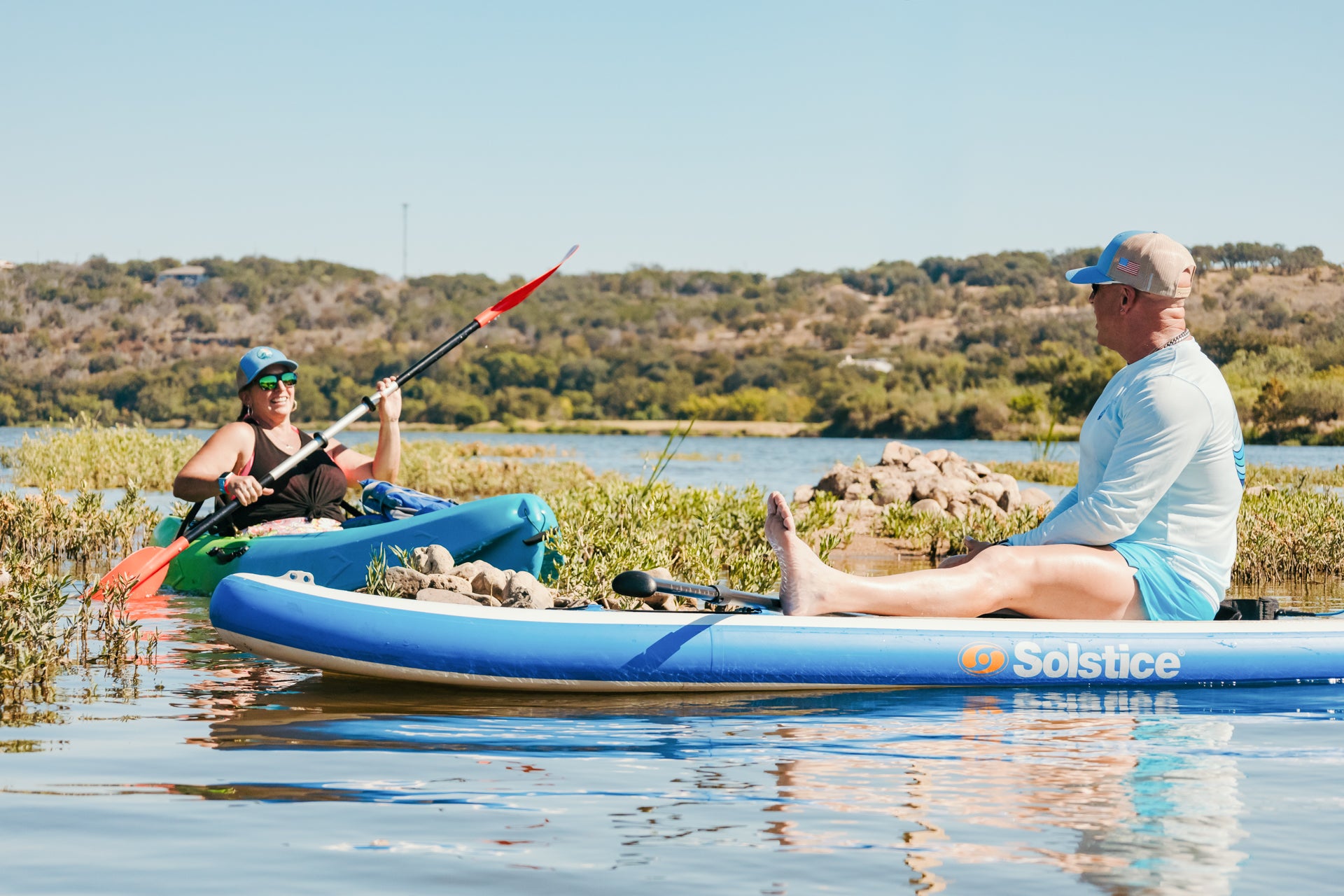 One person on an inflatable paddle board and another on a single kayak in Southern Hill Country
